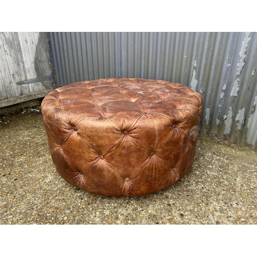 3 - A large swivel brown leather chesterfield footstool 100cm