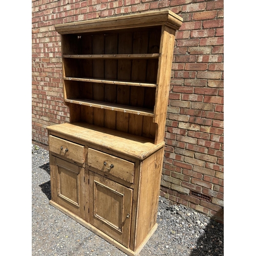 367 - A pine farmhouse dresser with plate rack top over two drawer and two door base 117x44x195