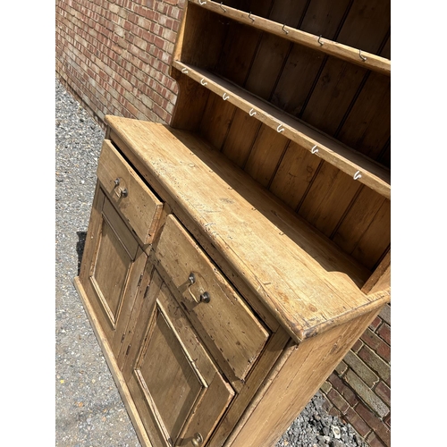 367 - A pine farmhouse dresser with plate rack top over two drawer and two door base 117x44x195