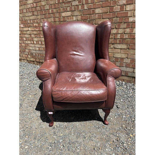 368 - A dark brown leather wing back armchair