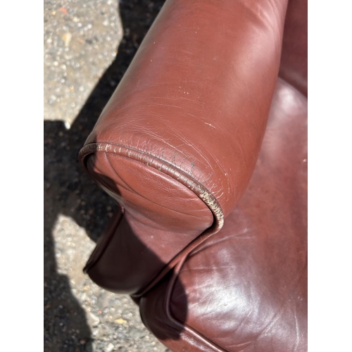 368 - A dark brown leather wing back armchair