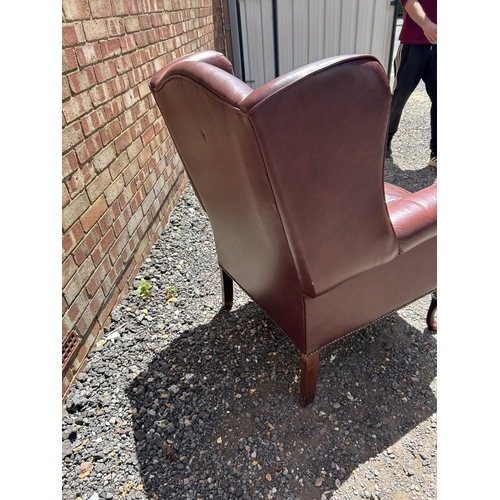 368 - A dark brown leather wing back armchair