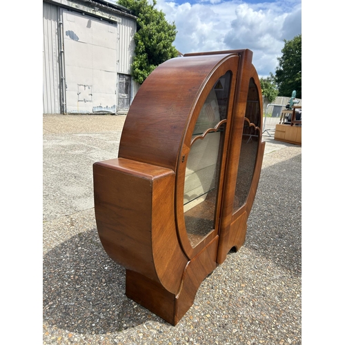 62 - An art deco walnut Wheel cabinet with glazed doors and two glazed shelves 137cm wide