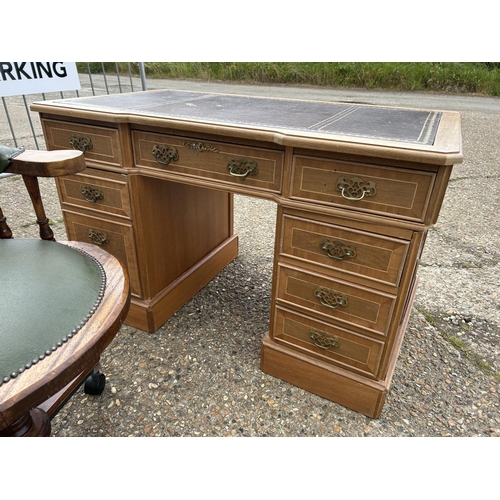 74 - A light oak twin pedestal desk with brown leatherette top together with a green leatherette swivel d... 