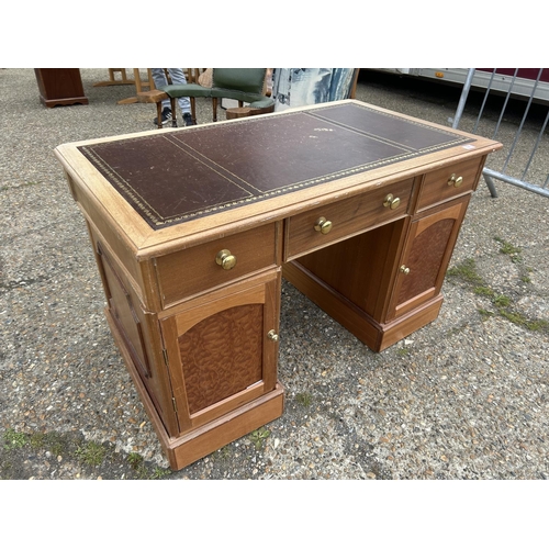 74 - A light oak twin pedestal desk with brown leatherette top together with a green leatherette swivel d... 