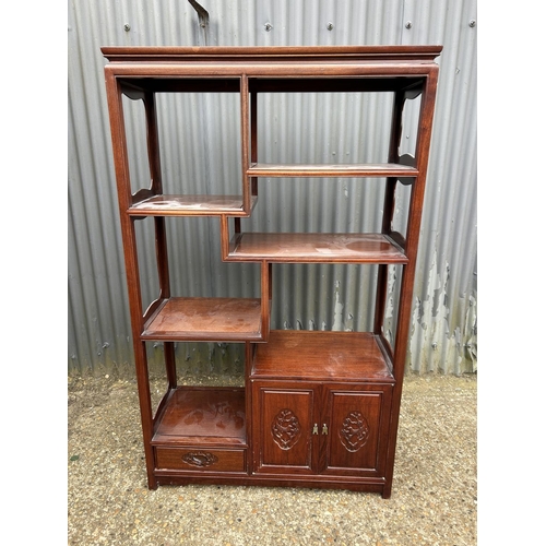 156 - An Oriental hardwood  double sided bookcase with cupboards and drawer to each side 100x40 x168