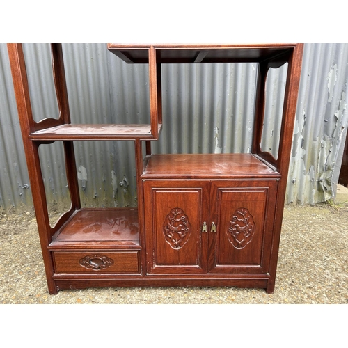 156 - An Oriental hardwood  double sided bookcase with cupboards and drawer to each side 100x40 x168