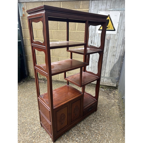 156 - An Oriental hardwood  double sided bookcase with cupboards and drawer to each side 100x40 x168