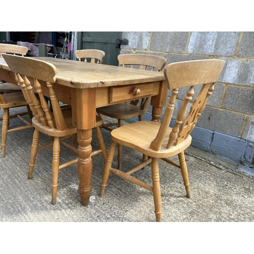 129 - A farmhouse style pine table fitted with drawer together with six pine chairs 184x86x77