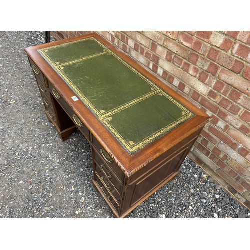 14 - A reproduction mahogany twin pedestal desk with a green leather top 123x66x77