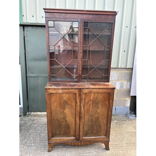 145 - A early victorian mahogany glazed bookcase cupboard  104x53x220