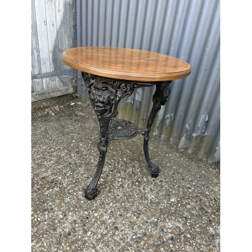 160p - A circular cast iron Britannia style table with oak top 58 diameter