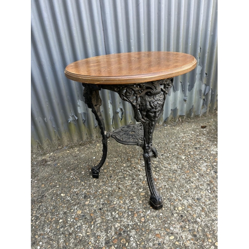 160p - A circular cast iron Britannia style table with oak top 58 diameter