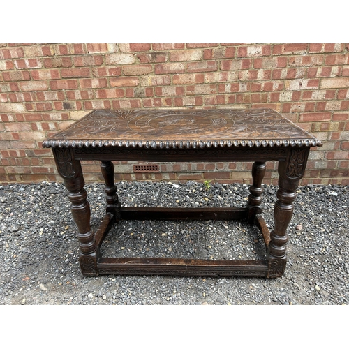 18 - An early carved oak centre table carved with a face to the top and marked 1668 110x62 x75