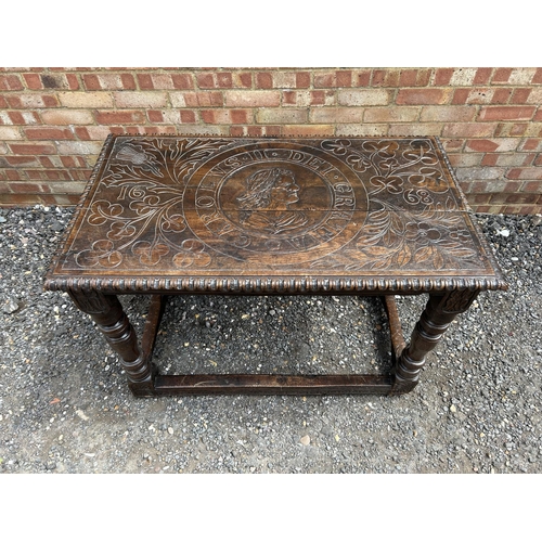 18 - An early carved oak centre table carved with a face to the top and marked 1668 110x62 x75