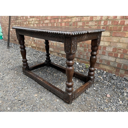 18 - An early carved oak centre table carved with a face to the top and marked 1668 110x62 x75