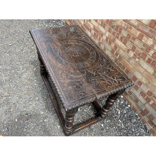 18 - An early carved oak centre table carved with a face to the top and marked 1668 110x62 x75