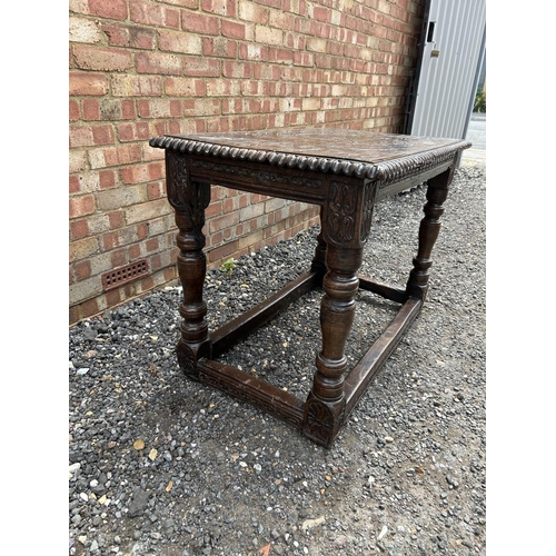 18 - An early carved oak centre table carved with a face to the top and marked 1668 110x62 x75