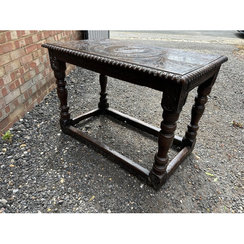 18 - An early carved oak centre table carved with a face to the top and marked 1668 110x62 x75