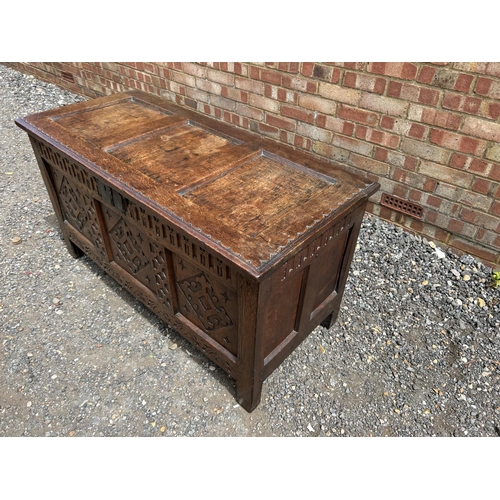 31 - A carved oak three panel blanket box chest 130x57x70