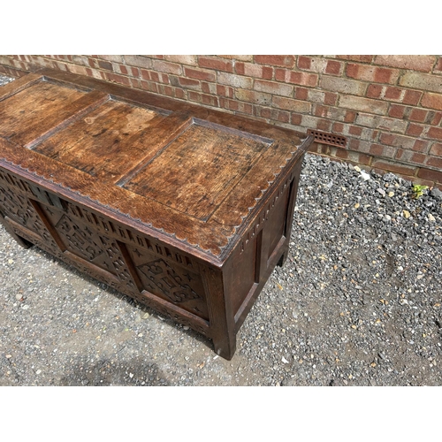 31 - A carved oak three panel blanket box chest 130x57x70