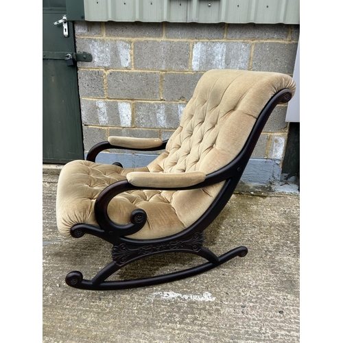 38 - A carved mahogany framed rocking chair with gold buttoned upholstery