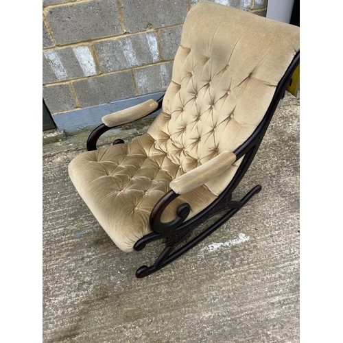 38 - A carved mahogany framed rocking chair with gold buttoned upholstery