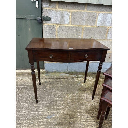 41 - A reproduction mahigany serpentine two drawer table together with repro nest of three tables