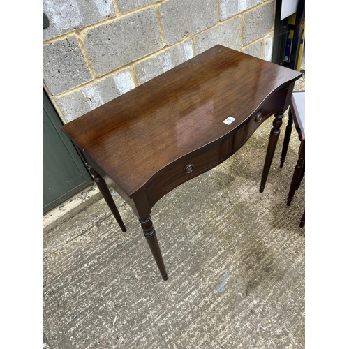 41 - A reproduction mahigany serpentine two drawer table together with repro nest of three tables