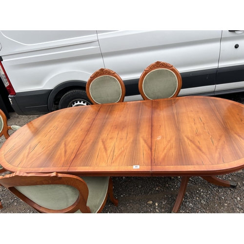 45 - A reproduction yew wood twin pedestal dining table with extension leaf and set of six matching chair... 