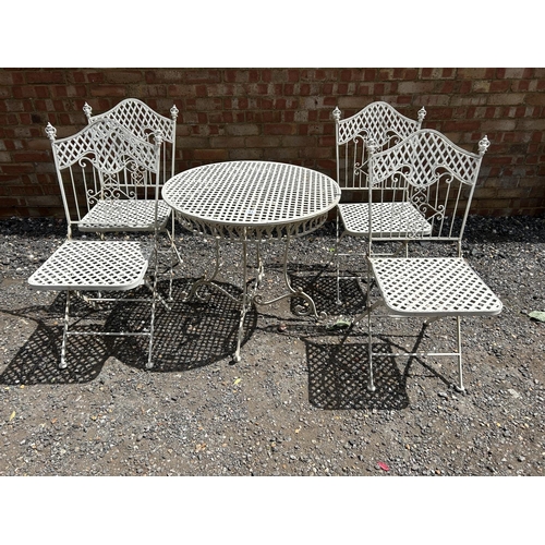 63 - A white painted folding metal bistro style table and four chairs 75 cm diameter