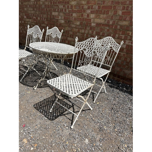 63 - A white painted folding metal bistro style table and four chairs 75 cm diameter