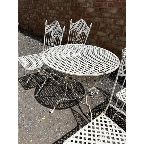 63 - A white painted folding metal bistro style table and four chairs 75 cm diameter