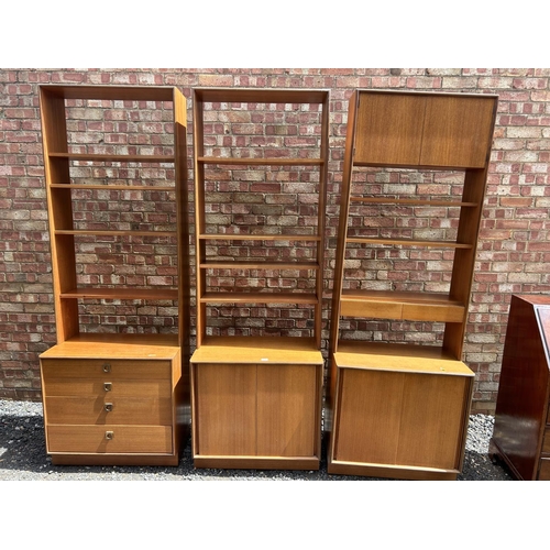 69 - A set of three g plan teak sectional bookcases, two with shelves and sliding door bases, one with fo... 