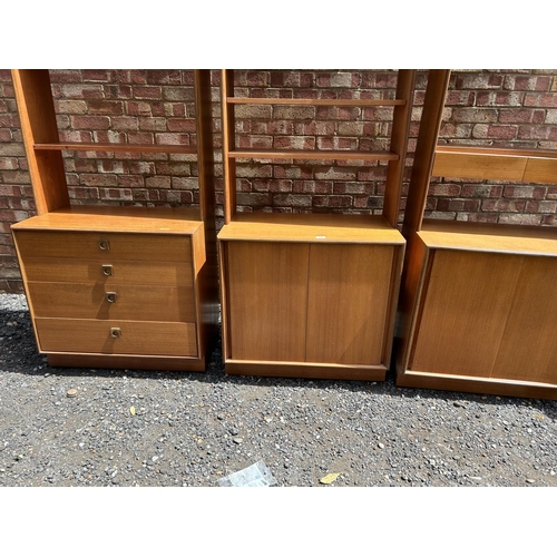 69 - A set of three g plan teak sectional bookcases, two with shelves and sliding door bases, one with fo... 