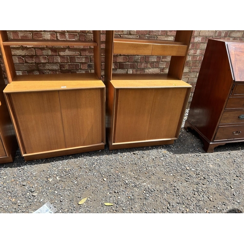 69 - A set of three g plan teak sectional bookcases, two with shelves and sliding door bases, one with fo... 