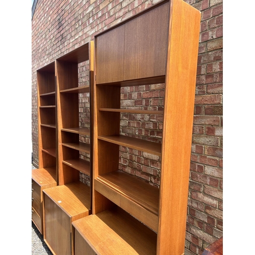 69 - A set of three g plan teak sectional bookcases, two with shelves and sliding door bases, one with fo... 