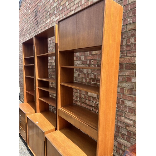 69 - A set of three g plan teak sectional bookcases, two with shelves and sliding door bases, one with fo... 