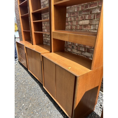 69 - A set of three g plan teak sectional bookcases, two with shelves and sliding door bases, one with fo... 