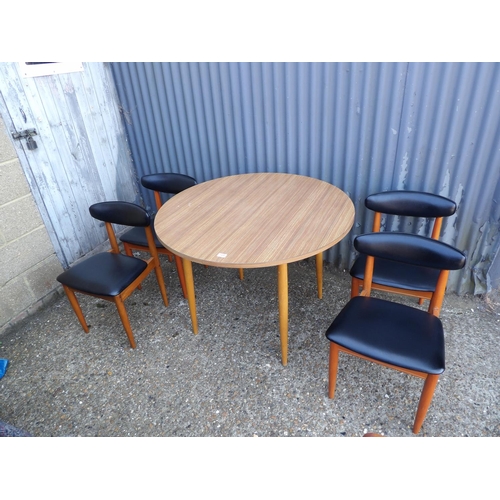 120 - A circular formica kitchen table together with four schrieber teak dining chairs