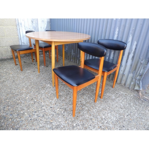 120 - A circular formica kitchen table together with four schrieber teak dining chairs