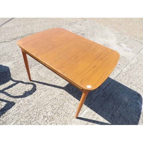 132 - AN extending teak dining table by Schreiber