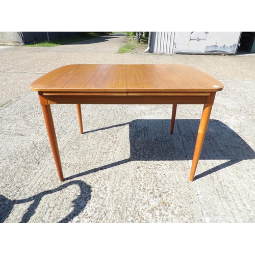 132 - AN extending teak dining table by Schreiber