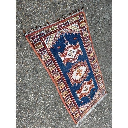 166 - A Persian pattern blue and red pattern carpet 107x198