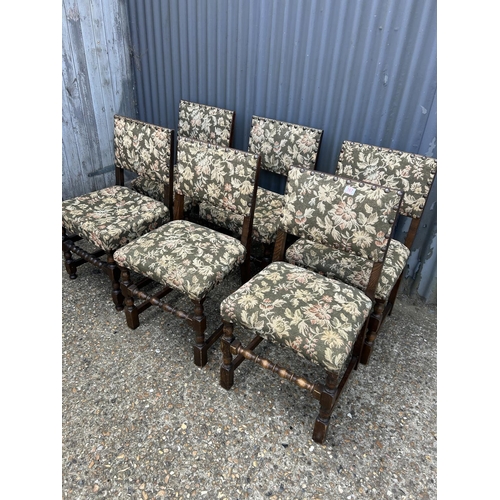 167 - A set of six solid oak dining chairs with green pattern seats with brass studwork