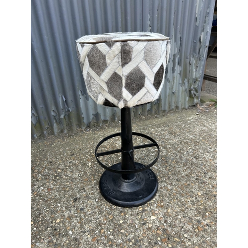 173 - An iron based bar stool with grey fur upholstered seat