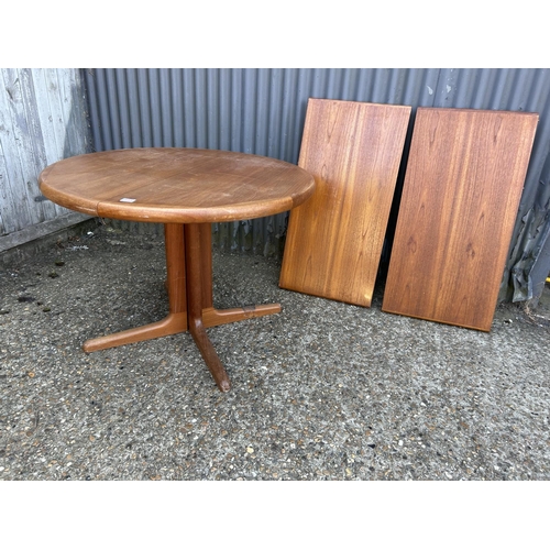 193 - A danish style circular teak extending dining table with two leaves