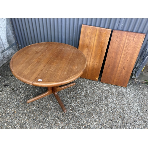 193 - A danish style circular teak extending dining table with two leaves