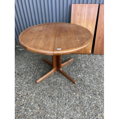 193 - A danish style circular teak extending dining table with two leaves