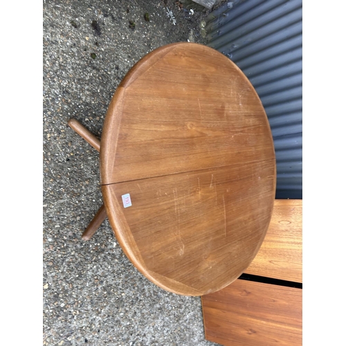 193 - A danish style circular teak extending dining table with two leaves